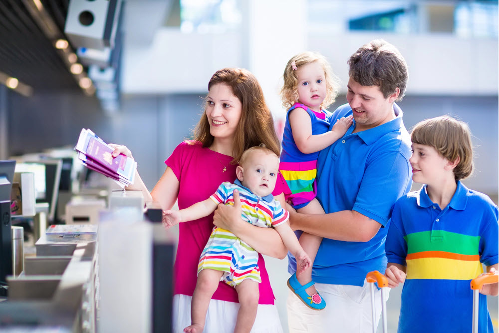 Familie i lufthavn med børn og baby